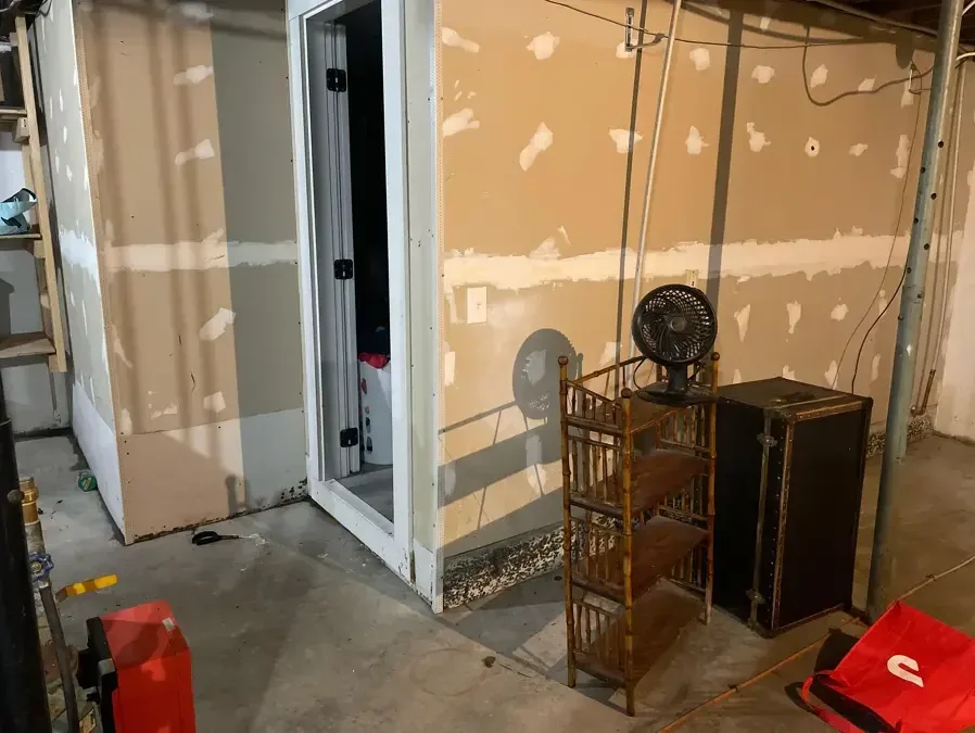 A wet vacuum, air movers and an LGR dehumidifier running together in an unfinished room during structural drying
